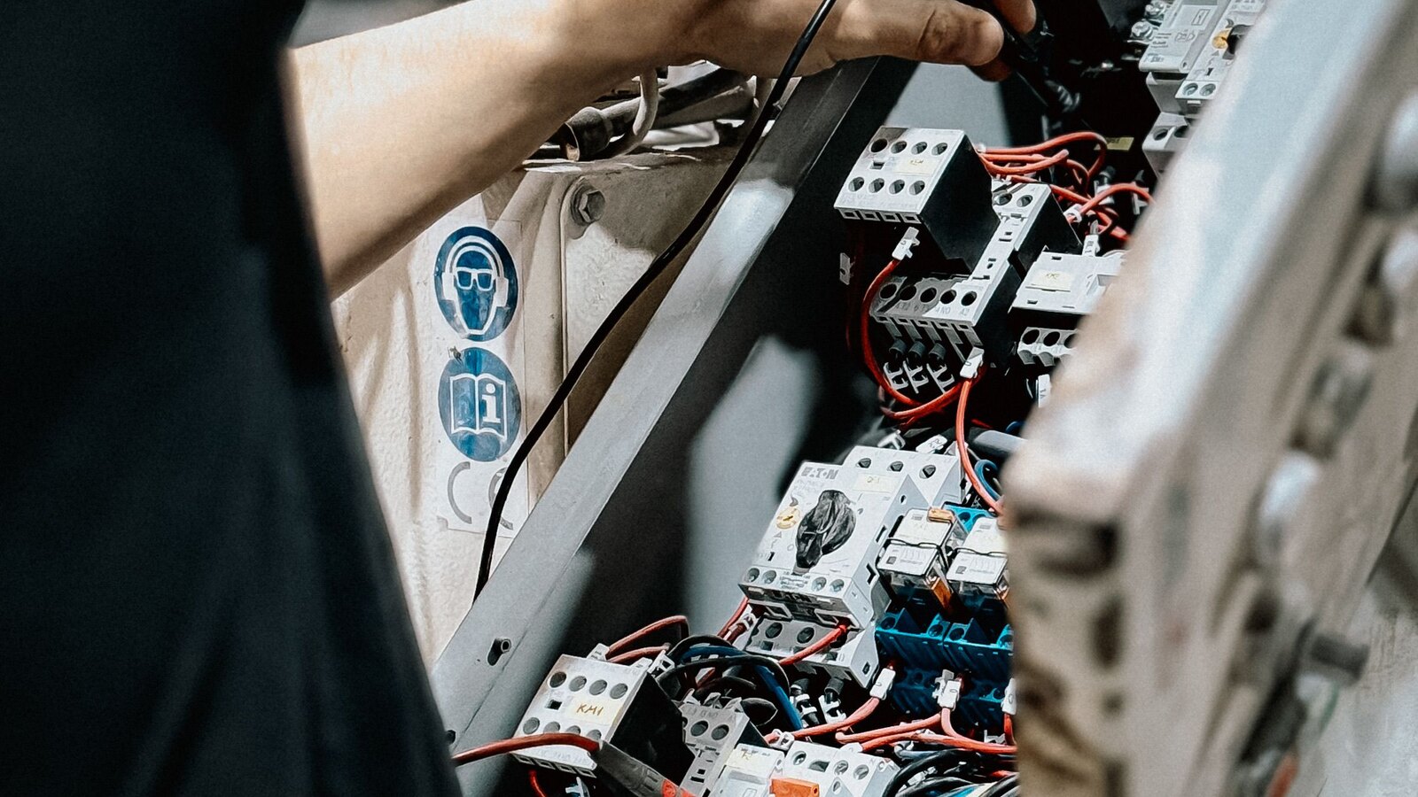 Electrician working inside a control panel